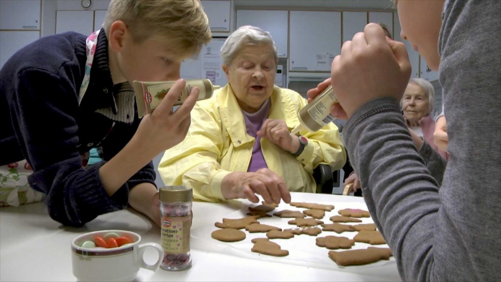 Palvelukeskuksen asukkaat ja Taivallahden peruskoulun oppilaat koristelemassa piparkakkuja.